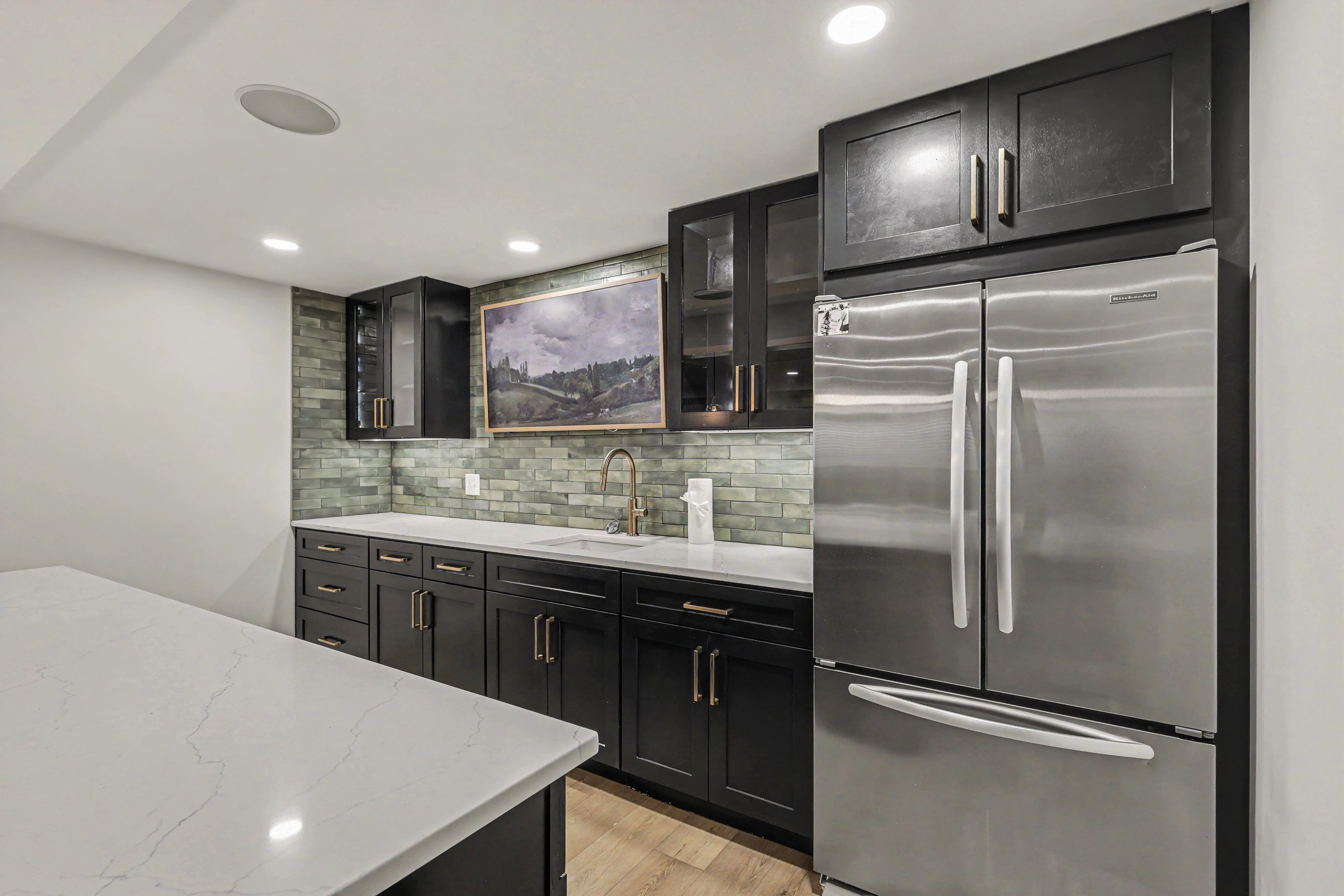 Basement kitchenette with glass upper cabinets and refrigerator in a Prairie Village basement remodel